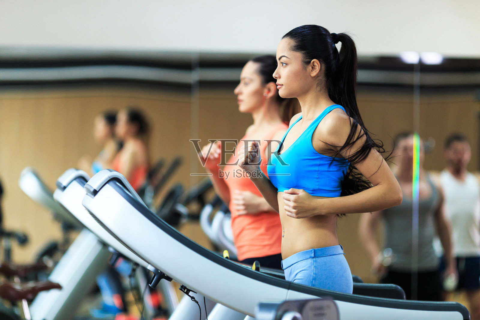 两个女人在健身房的跑步机上跑步照片摄影图片