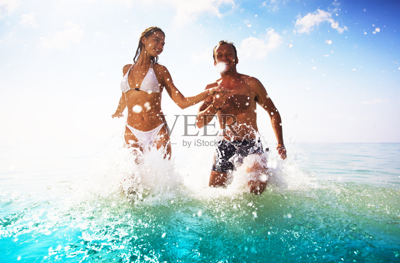 一对漂亮的夫妇在海滩上玩得很开心。照片摄影图片