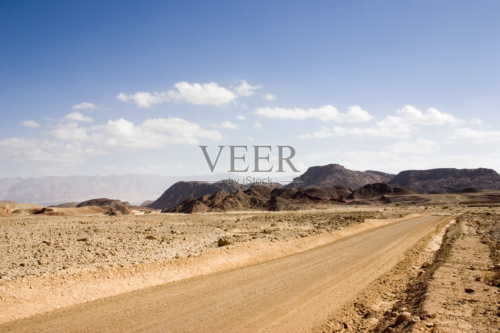 沙漠之路通向蓝天白云的高山照片摄影图片