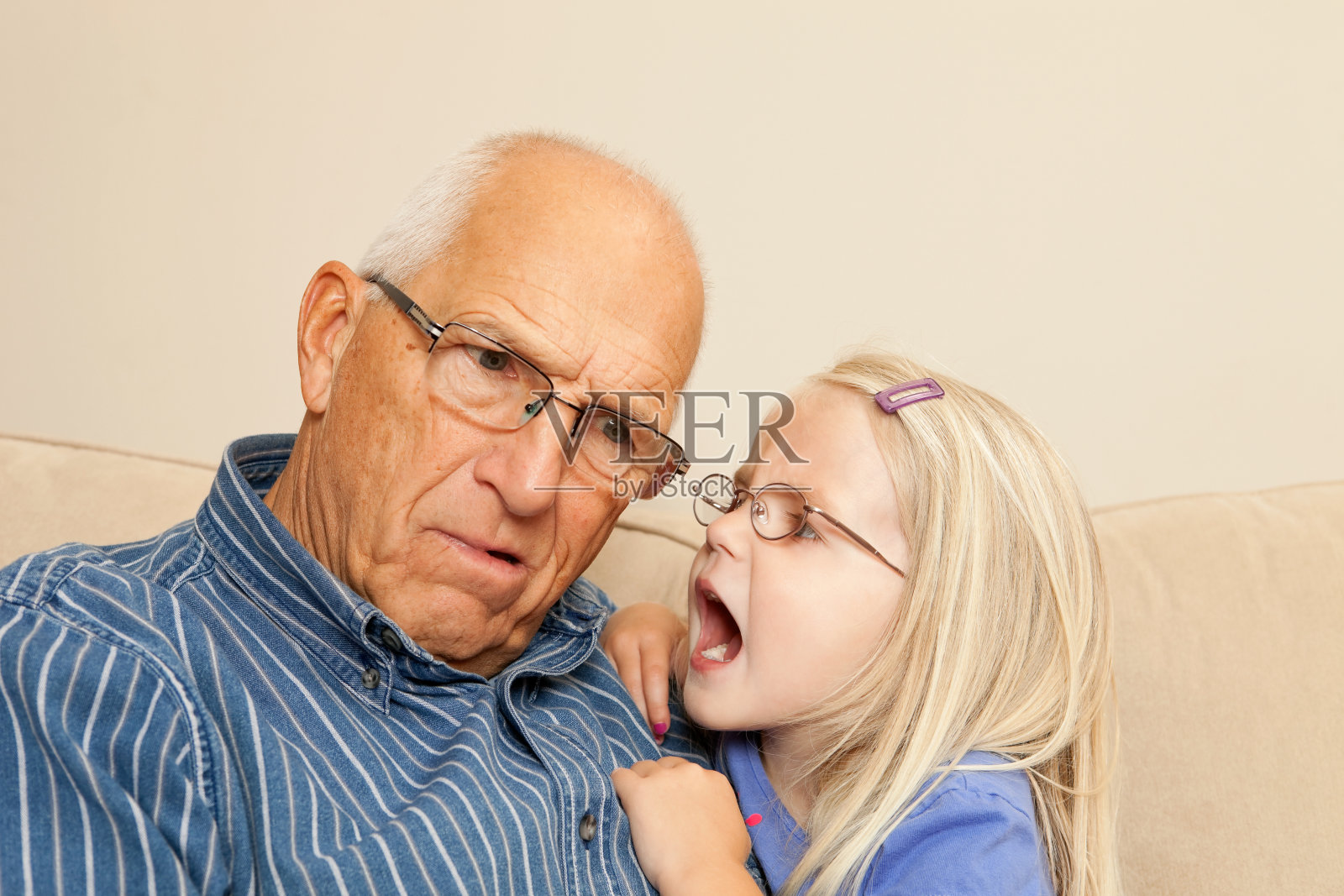 小女孩对着爷爷的耳朵大喊照片摄影图片
