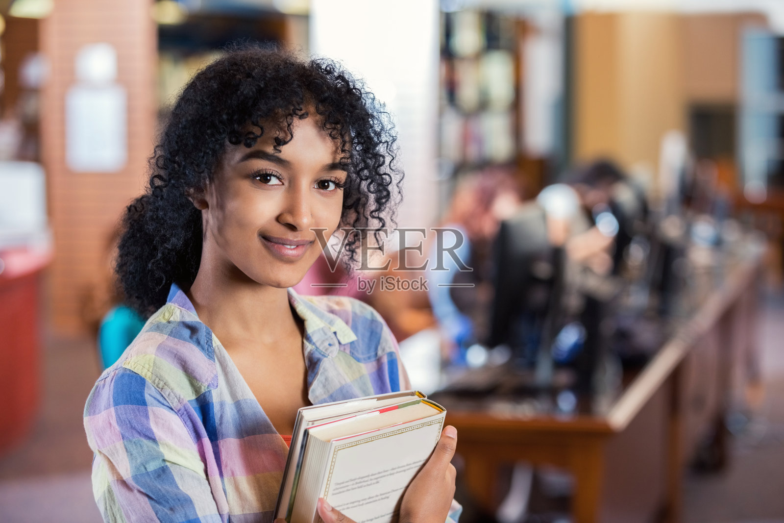 非裔美国大学生站在现代图书馆里照片摄影图片
