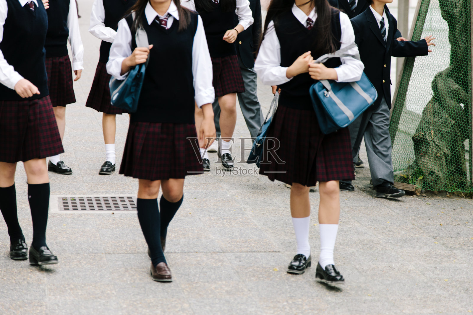 日本的高中。学校的孩子们走在外面，穿着无法辨认的校服照片摄影图片