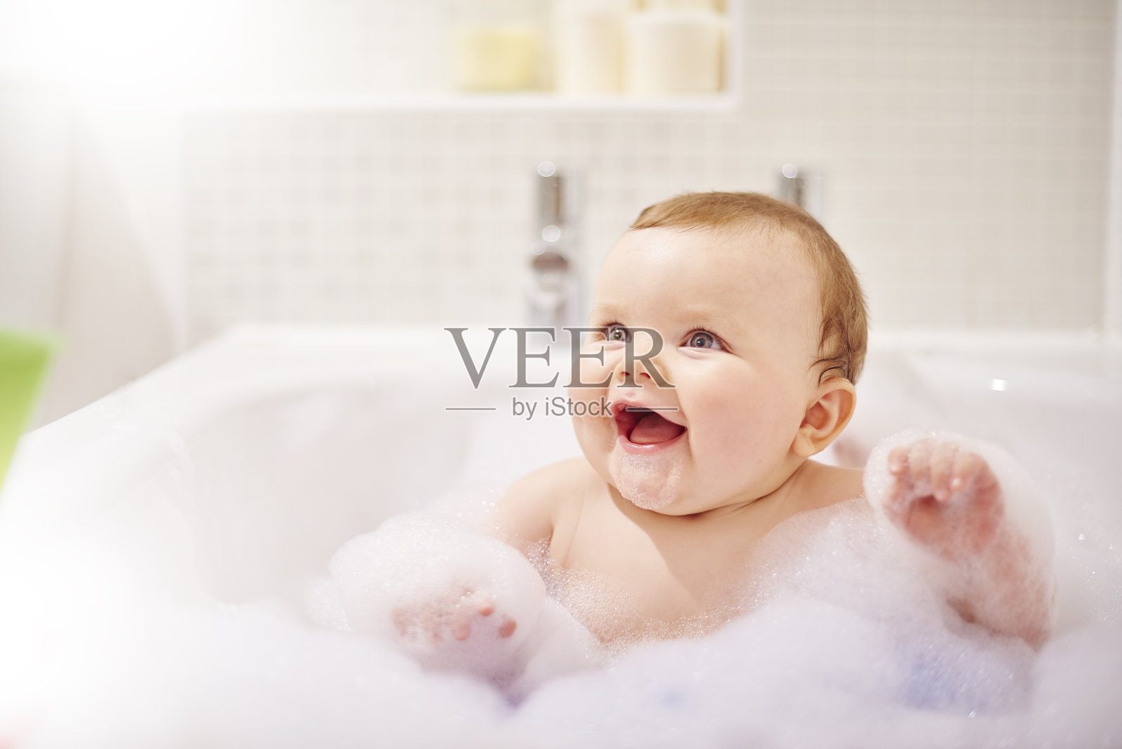 小男孩在他的泡泡浴里笑照片摄影图片