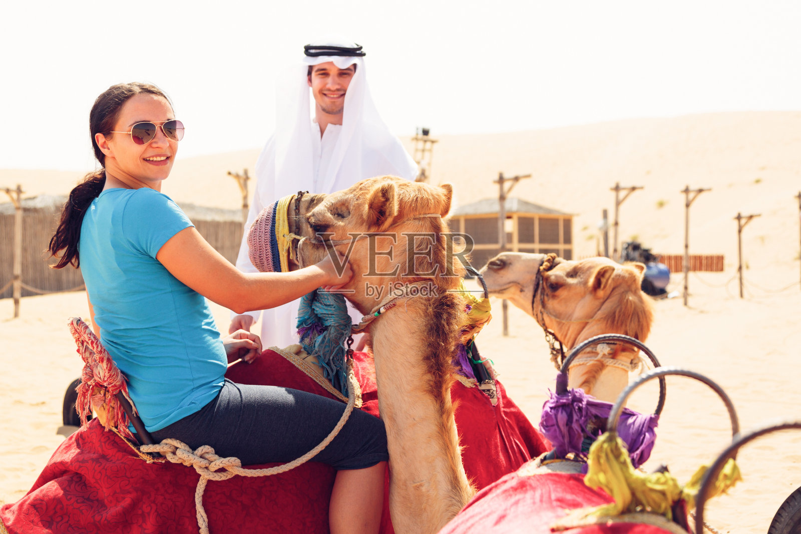 阿拉伯男子和骑骆驼的游客照片摄影图片