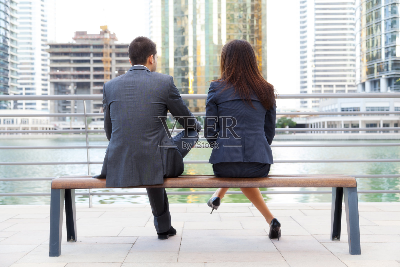 一对商务夫妇坐在长椅上照片摄影图片