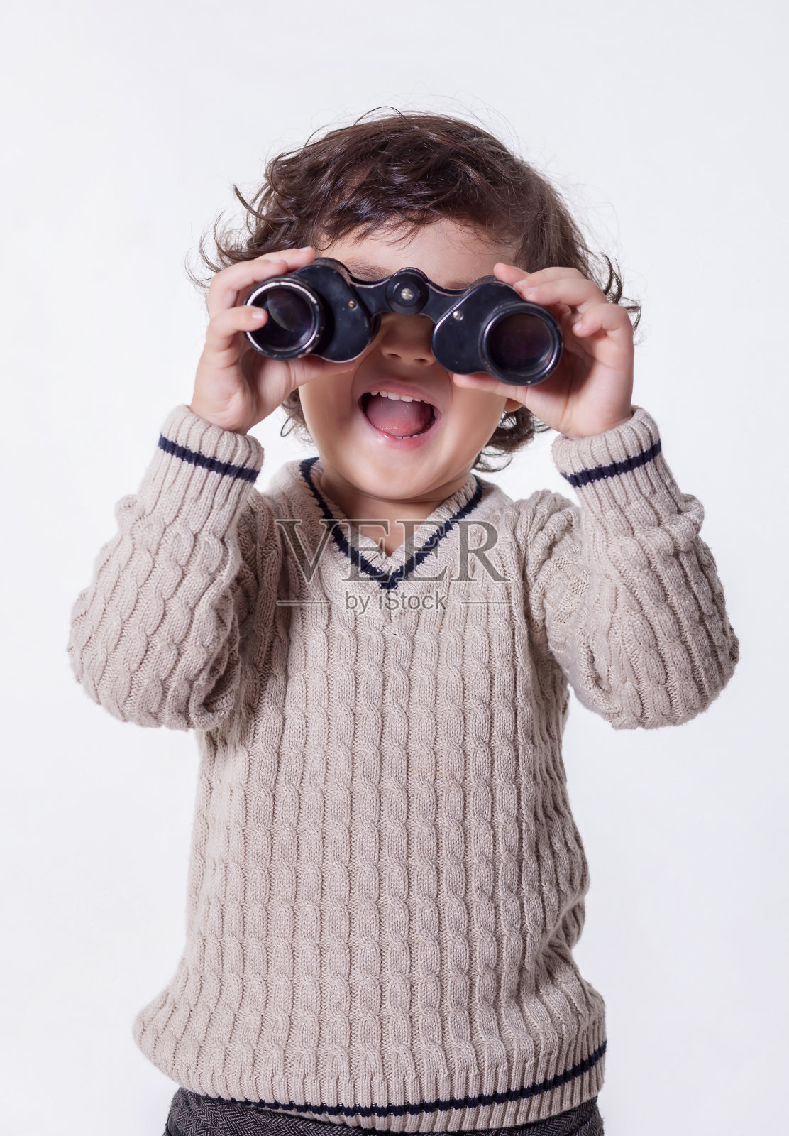 微笑的男孩站在望远镜和指向上面照片摄影图片