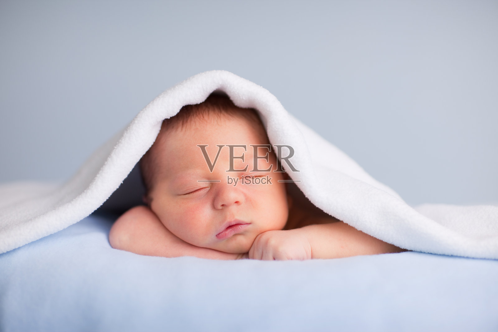 新生男婴在柔软的毯子下安静地睡觉照片摄影图片