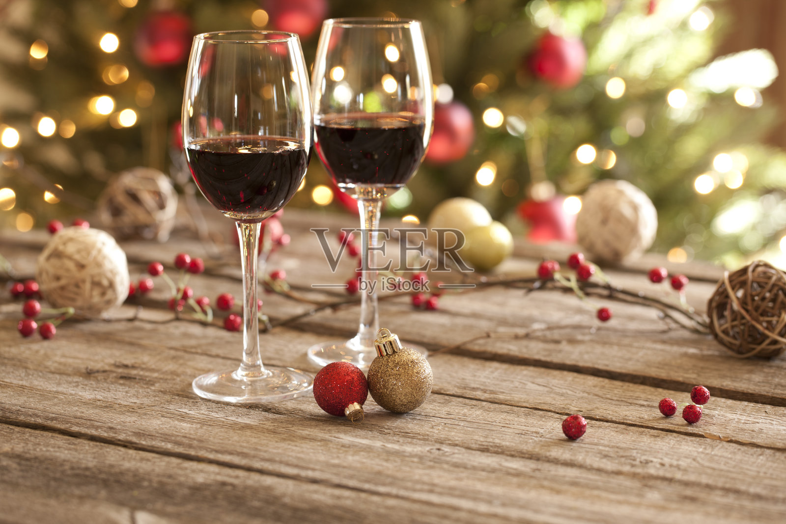 圣诞佳节红酒、老木桌、装饰品和圣诞树照片摄影图片