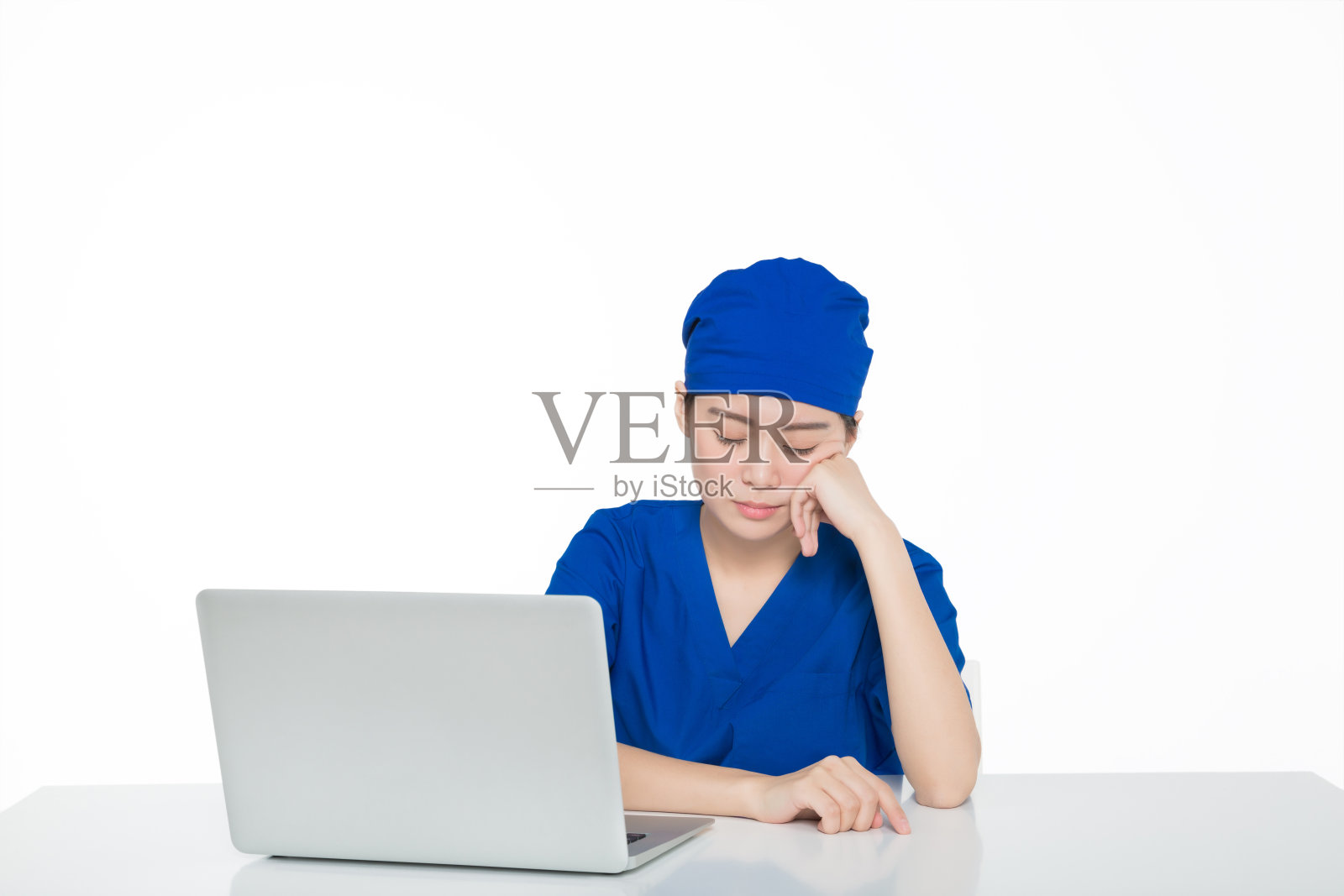 穿着手术服的女医生，手提电脑孤立在白色背景上照片摄影图片