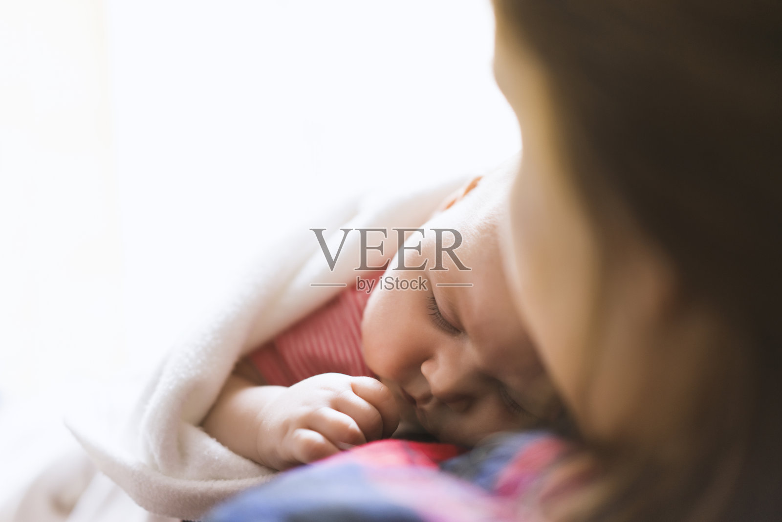 刚出生的婴儿躺在妈妈的胸前照片摄影图片