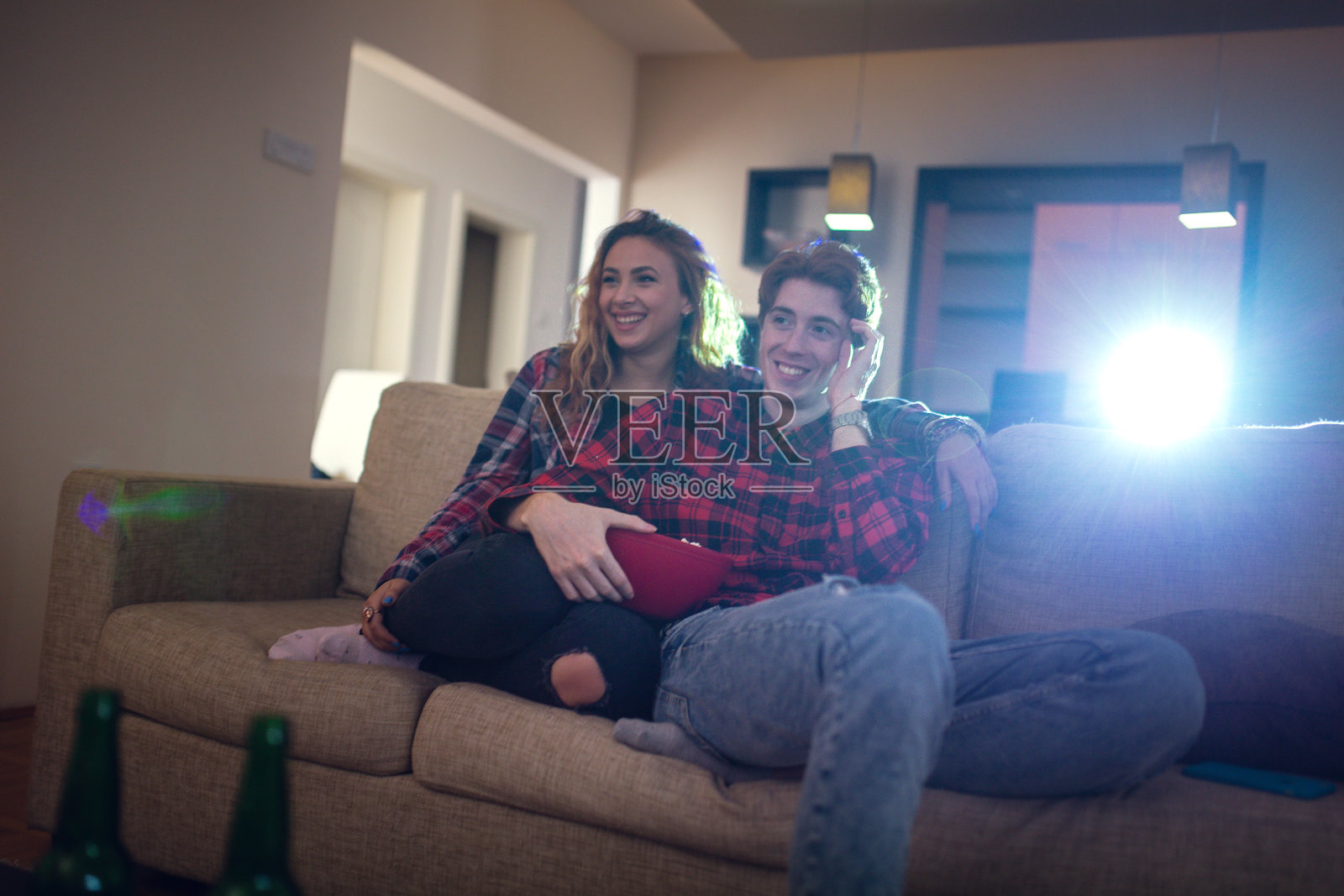 一对年轻幸福的夫妇在看放映机上的电影照片摄影图片