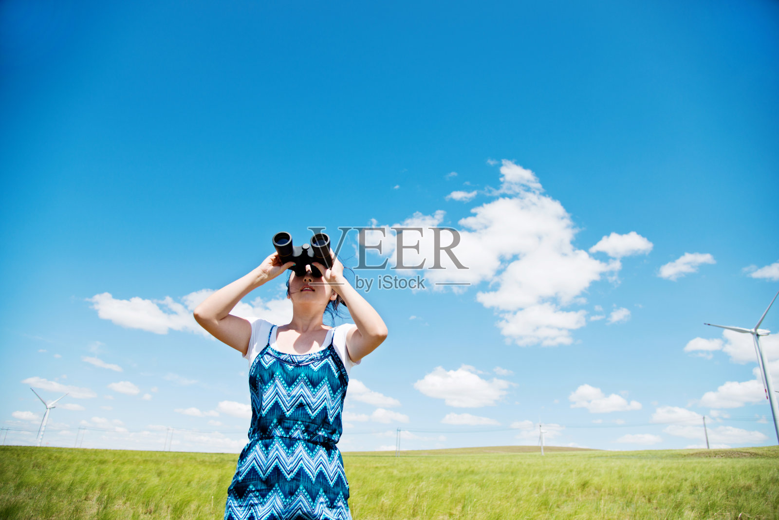 一位妇女用双筒望远镜看天空照片摄影图片