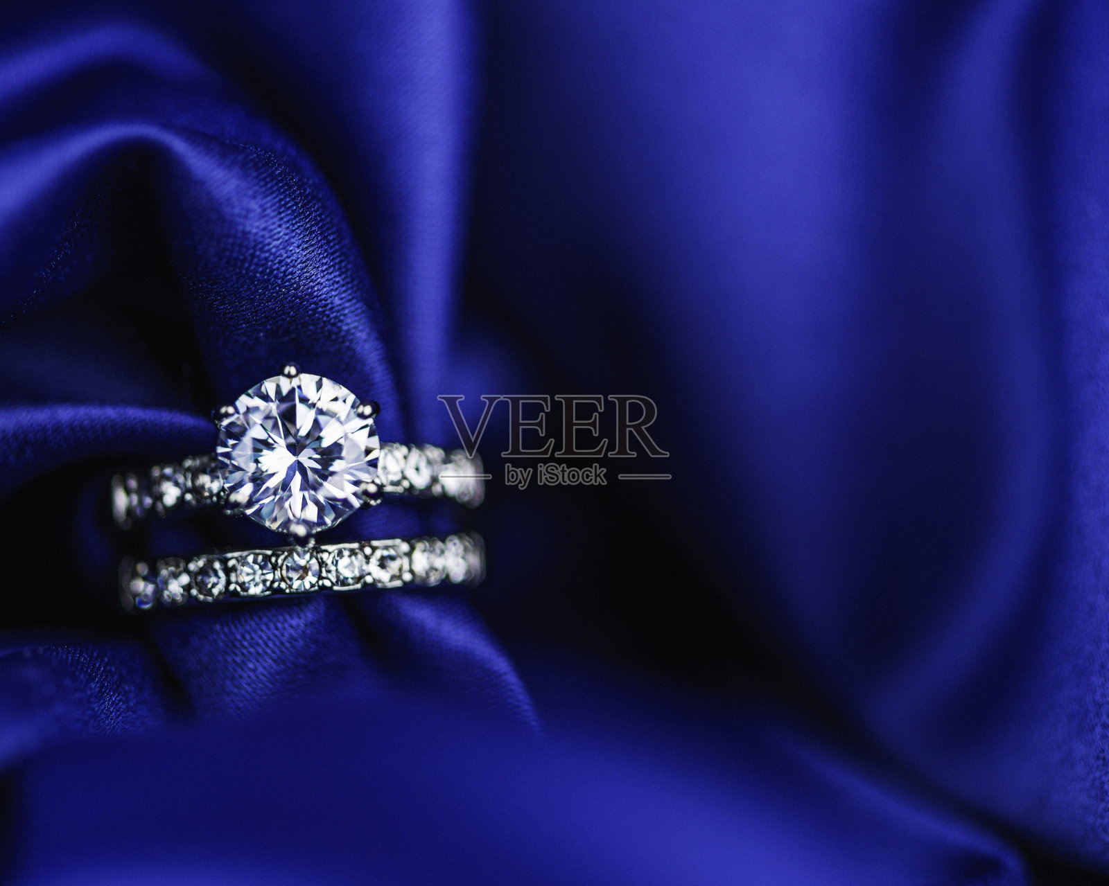 钻石戒指在丰富的缎子背景照片摄影图片