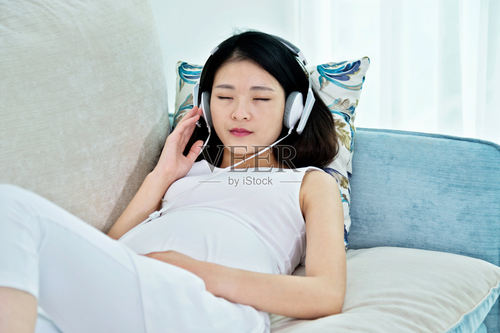 孕妇坐在沙发上听音乐照片摄影图片