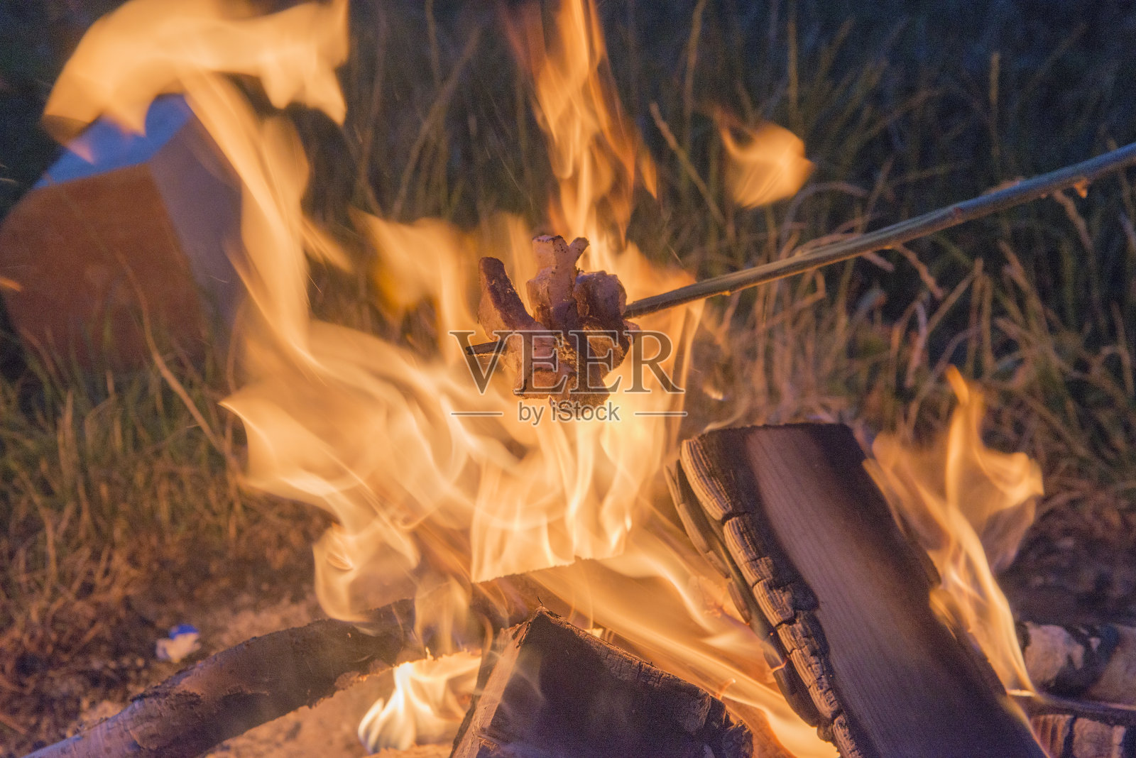 在火上和肉一起烤。照片摄影图片