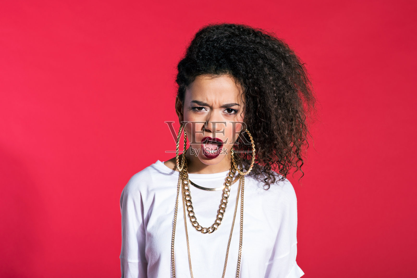 愤怒的拉丁年轻女子嘻哈风格的红色背景照片摄影图片