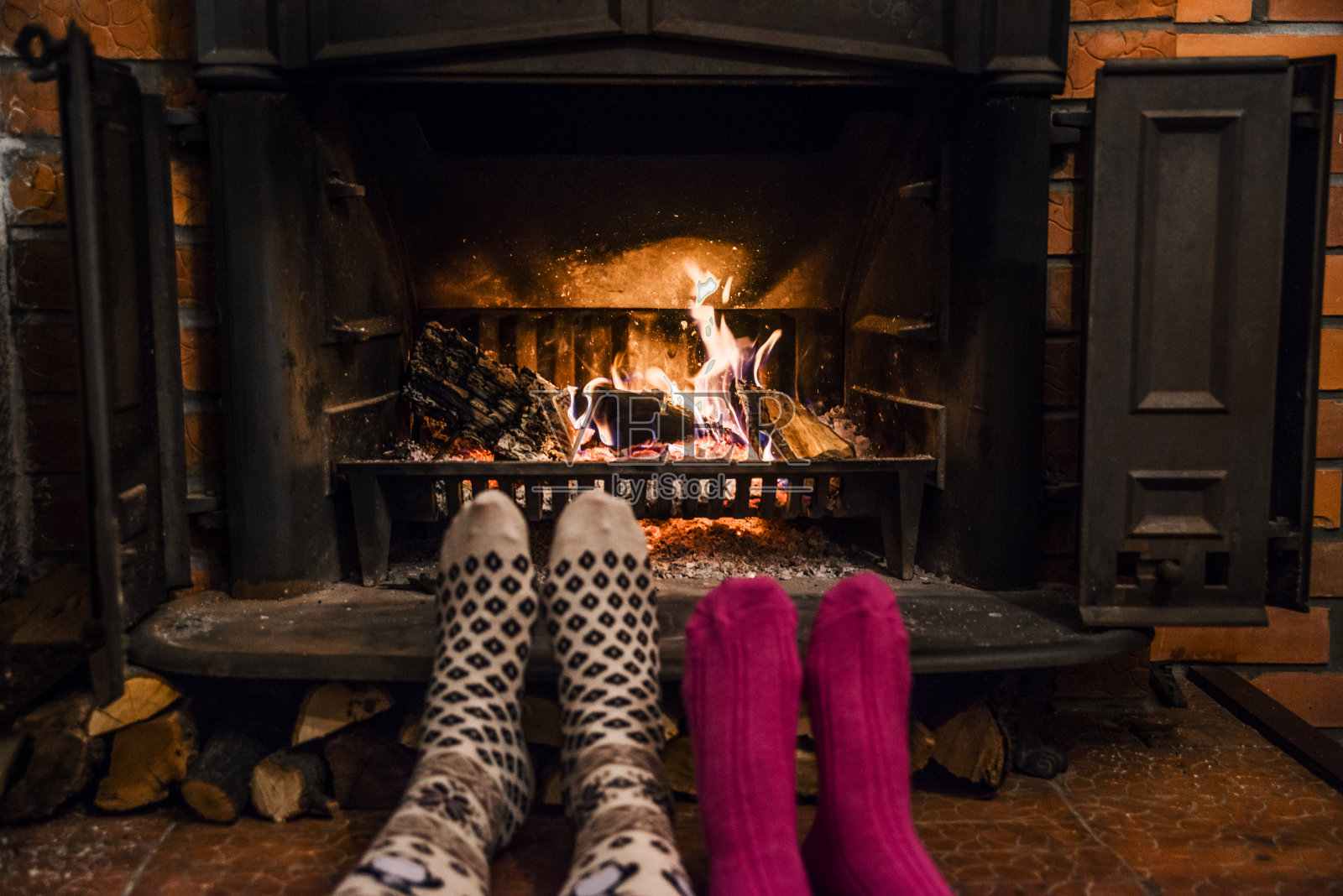 脚上穿着羊毛袜子，在温暖的炉火旁取暖照片摄影图片