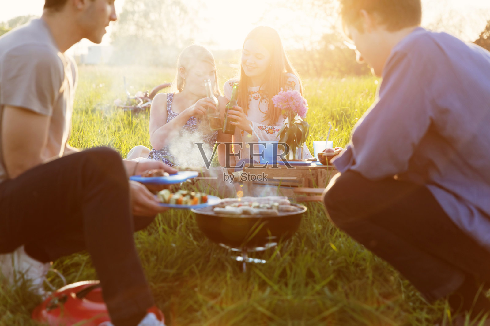 朋友们有乐趣的野餐和烧烤在夏天照片摄影图片