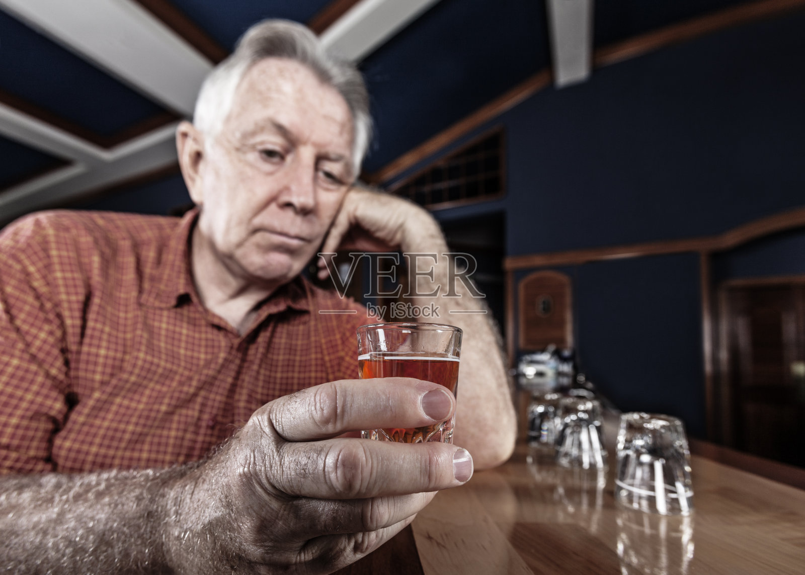 在酒吧里，一位年长的成年男子想再喝一杯照片摄影图片