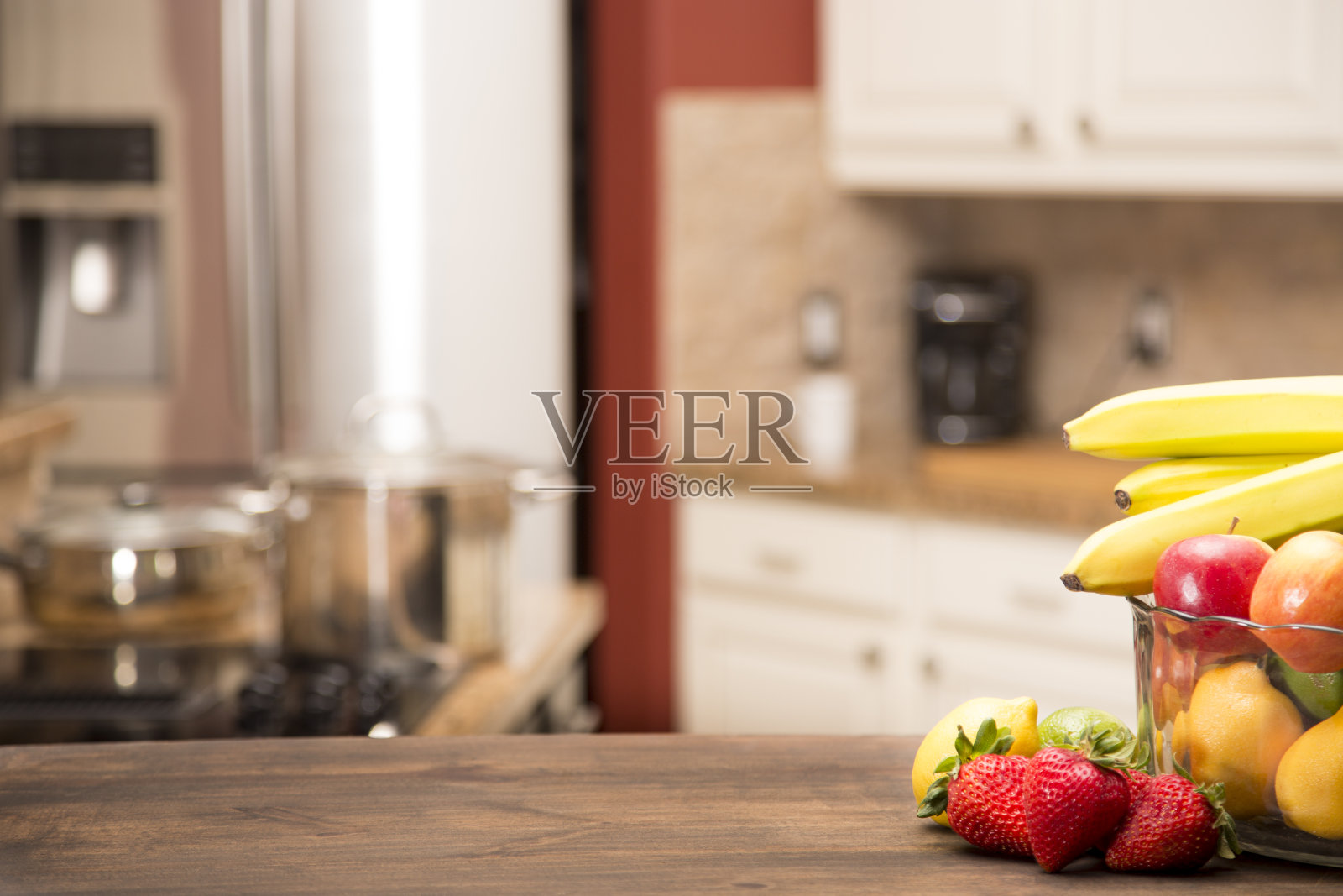 家庭厨房离焦与水果在桌子上的前景。照片摄影图片