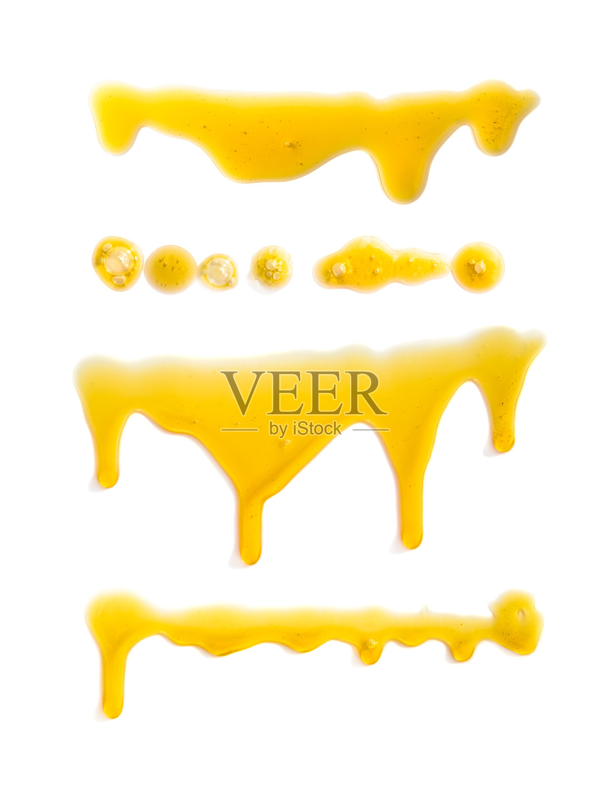 白色背景上的一组黄色油渍和液滴照片摄影图片