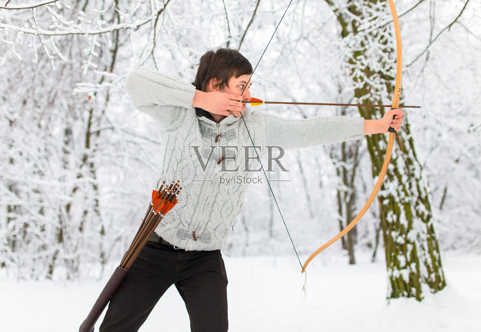 弓箭手在冬日的树林里，训练年轻的运动员。照片摄影图片