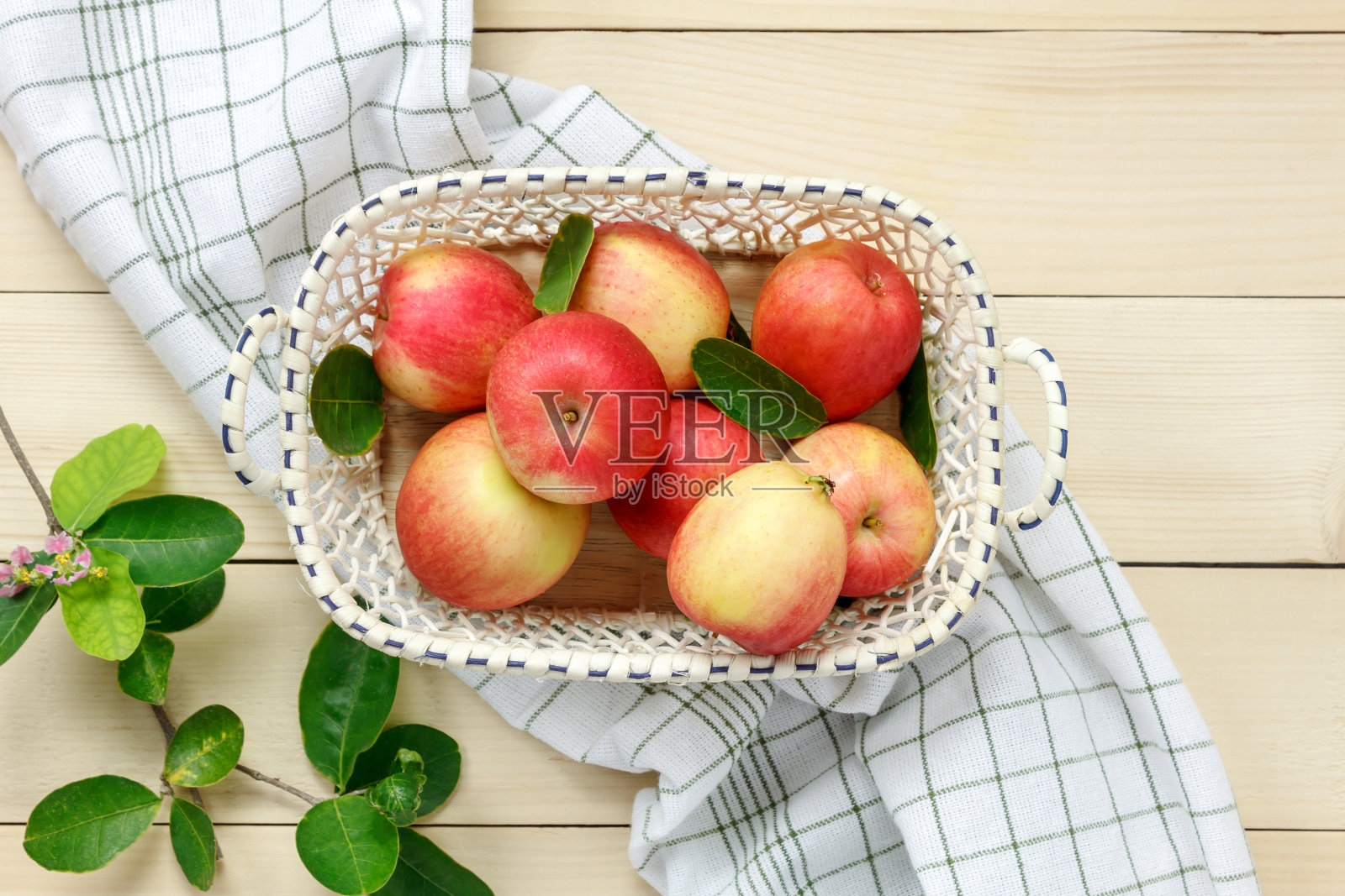 顶视图红苹果和树叶在篮子上木制。照片摄影图片