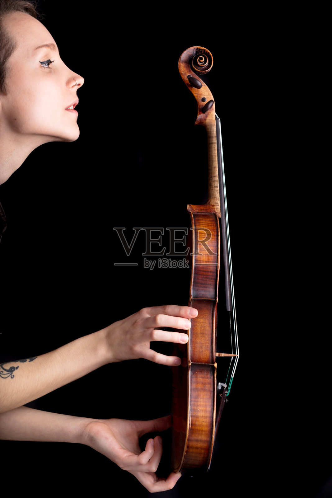黑色背景上的女人侧写和小提琴照片摄影图片