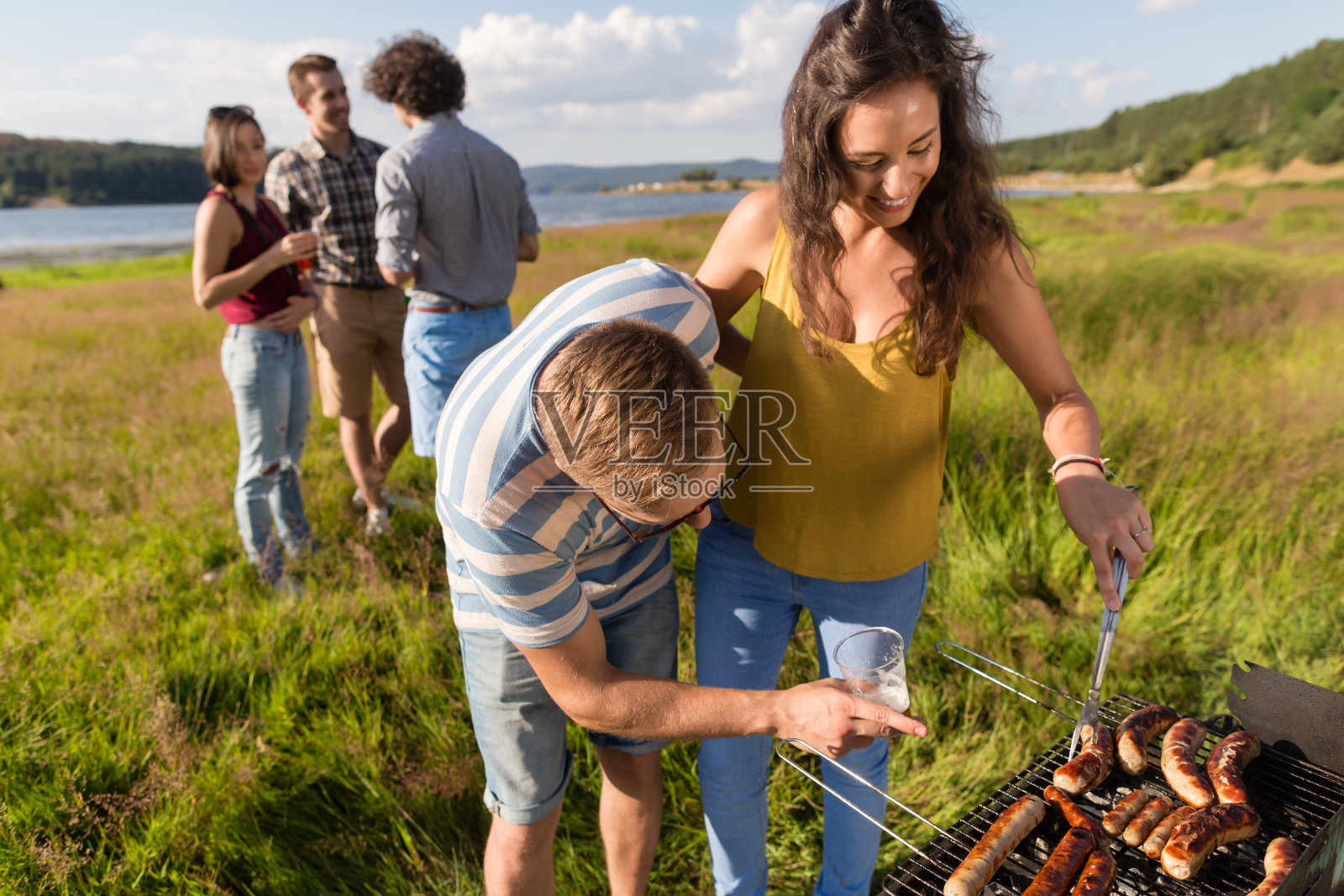 男人和女人在烧烤架上烤德国香肠照片摄影图片