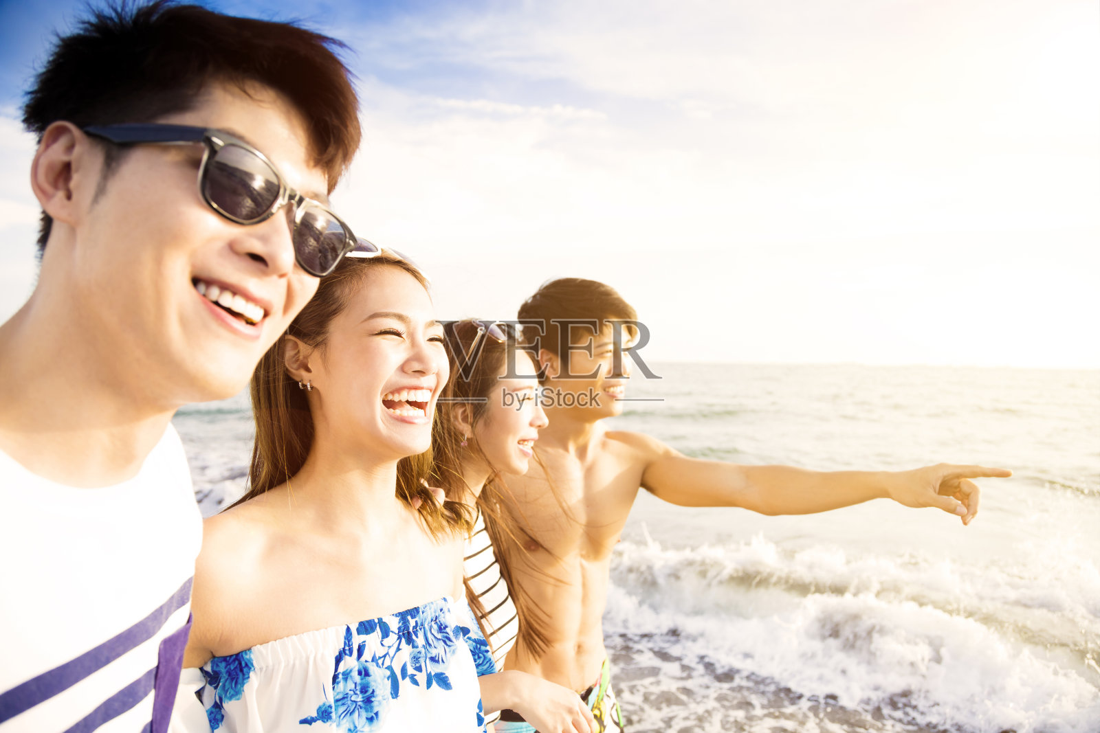 一群快乐的年轻人在海滩上散步享受暑假照片摄影图片