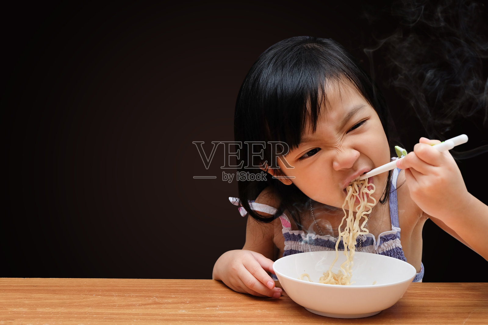 亚洲女孩吃方便面孤立在黑色背景照片摄影图片