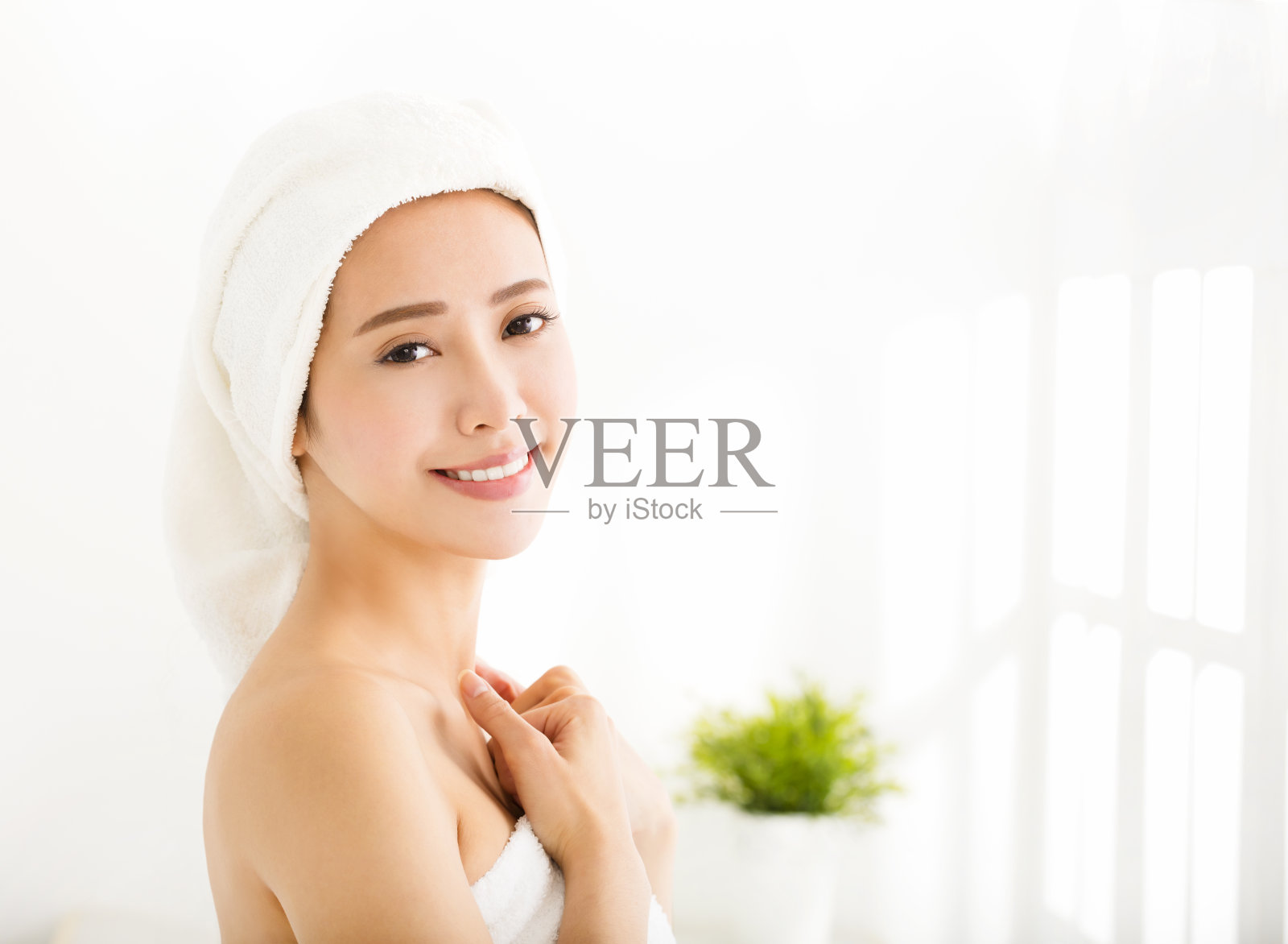 一个年轻女子，洗澡后用毛巾盖在头上照片摄影图片