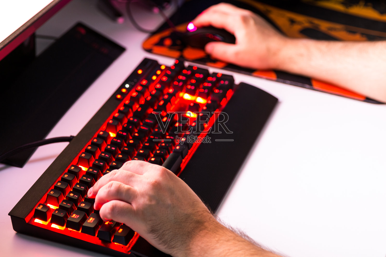 用手柄、键盘、鼠标在定制的桌面上玩电脑游戏。照片摄影图片