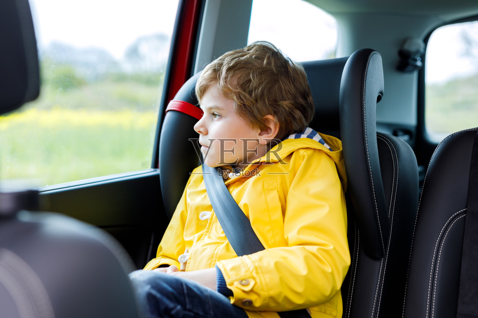 一个疲惫的学前班小男孩在交通堵塞时坐在车里照片摄影图片