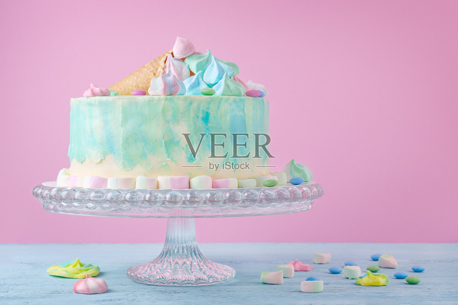 色彩柔和的生日蛋糕，粉红色背景上有棉花糖和糖果，选择性聚焦照片摄影图片