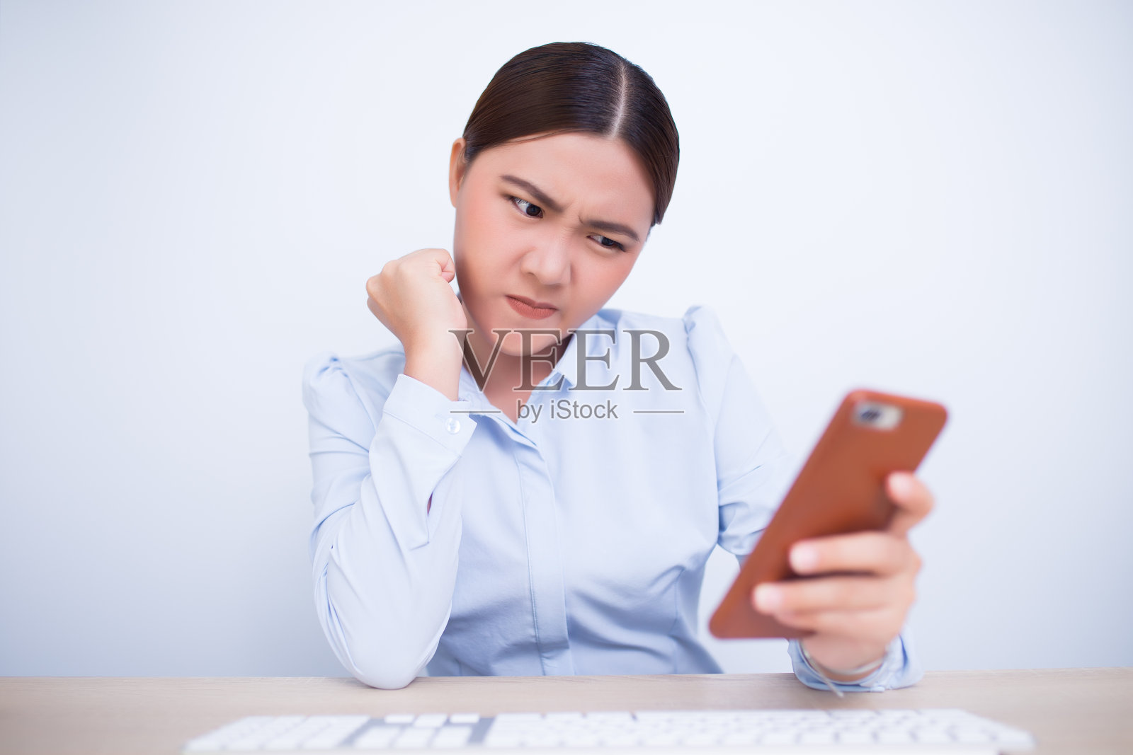 愤怒的女性在办公室使用智能手机照片摄影图片