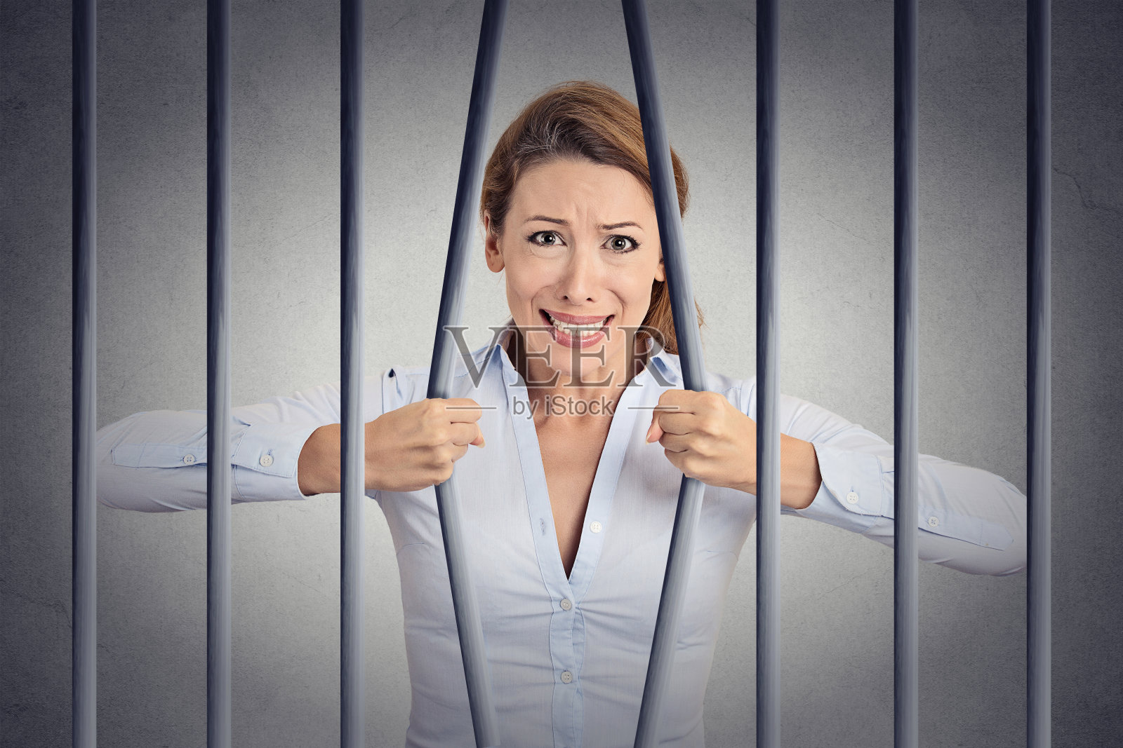 压力绝望愤怒的女商人弯曲她的监狱牢房的栏杆照片摄影图片