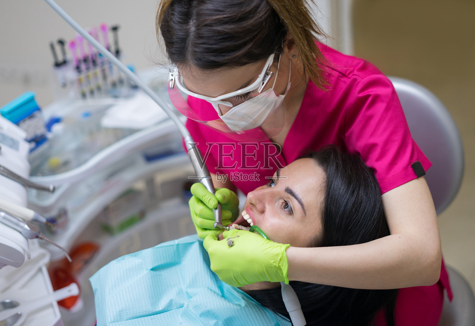牙医正在给一个女人清洁牙齿照片摄影图片