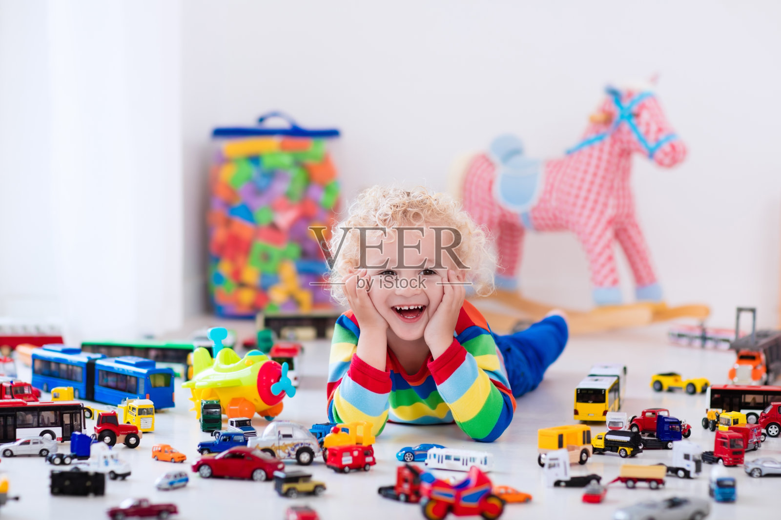 卷毛小男孩在玩玩具车照片摄影图片