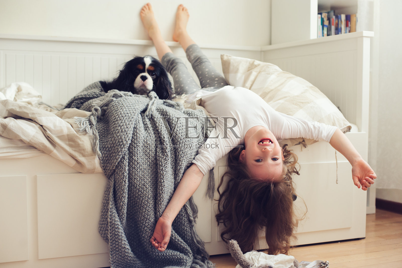 快乐的小女孩早上醒来在她的卧室和狗在床上照片摄影图片