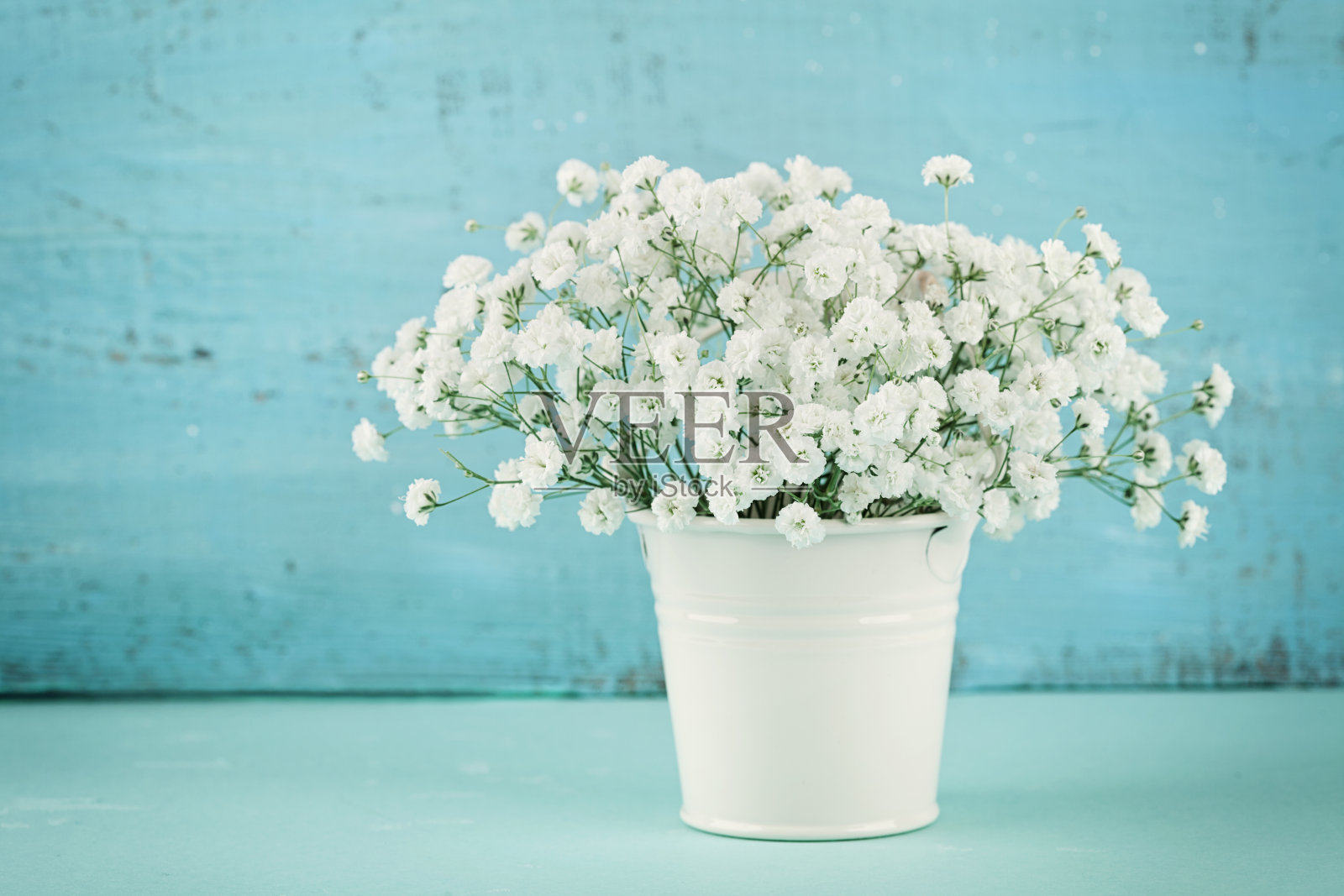美丽的gypsophilla春天花束在白色花瓶。的背景。乡村风格。照片摄影图片