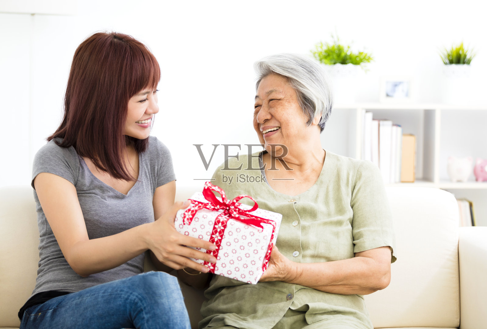 快乐的年轻女子给奶奶礼物照片摄影图片