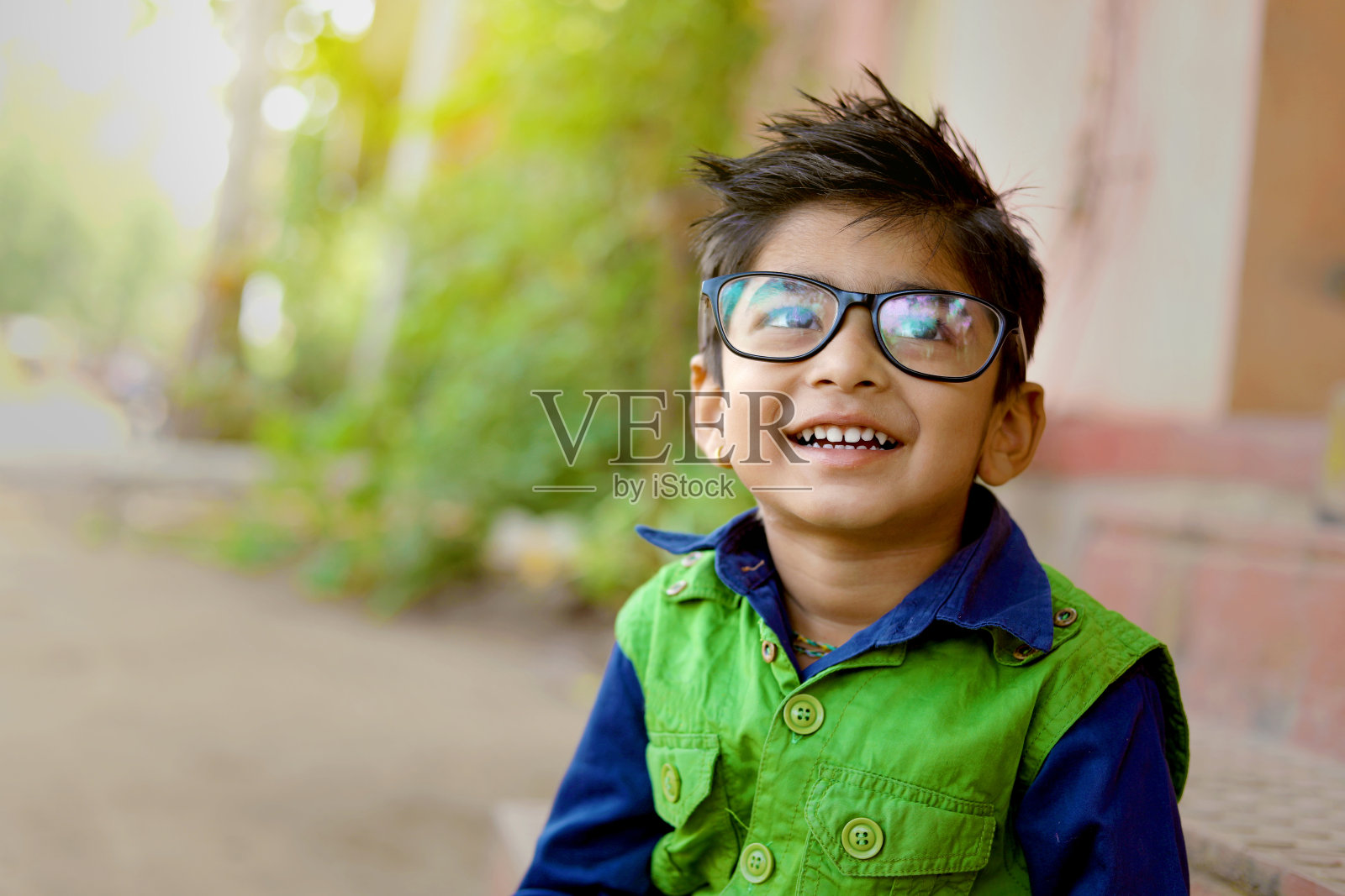可爱的小学生戴着眼镜在镜头前看书照片摄影图片_ID:348781182-Veer图库