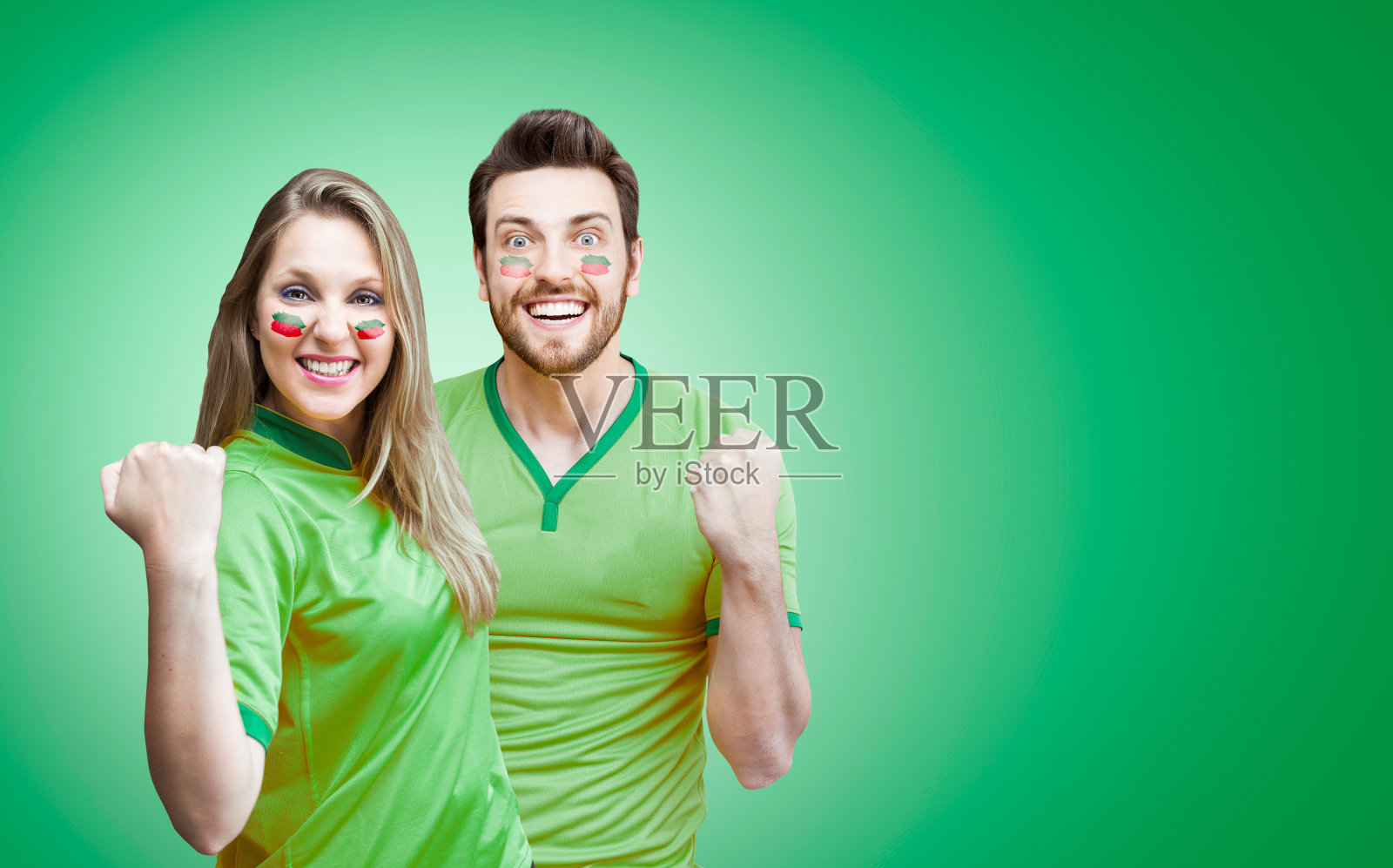 一对球迷/运动员穿着绿色制服庆祝照片摄影图片