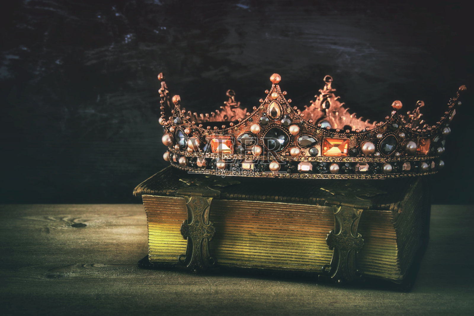 在旧书上美丽的女王/国王王冠的低调形象照片摄影图片