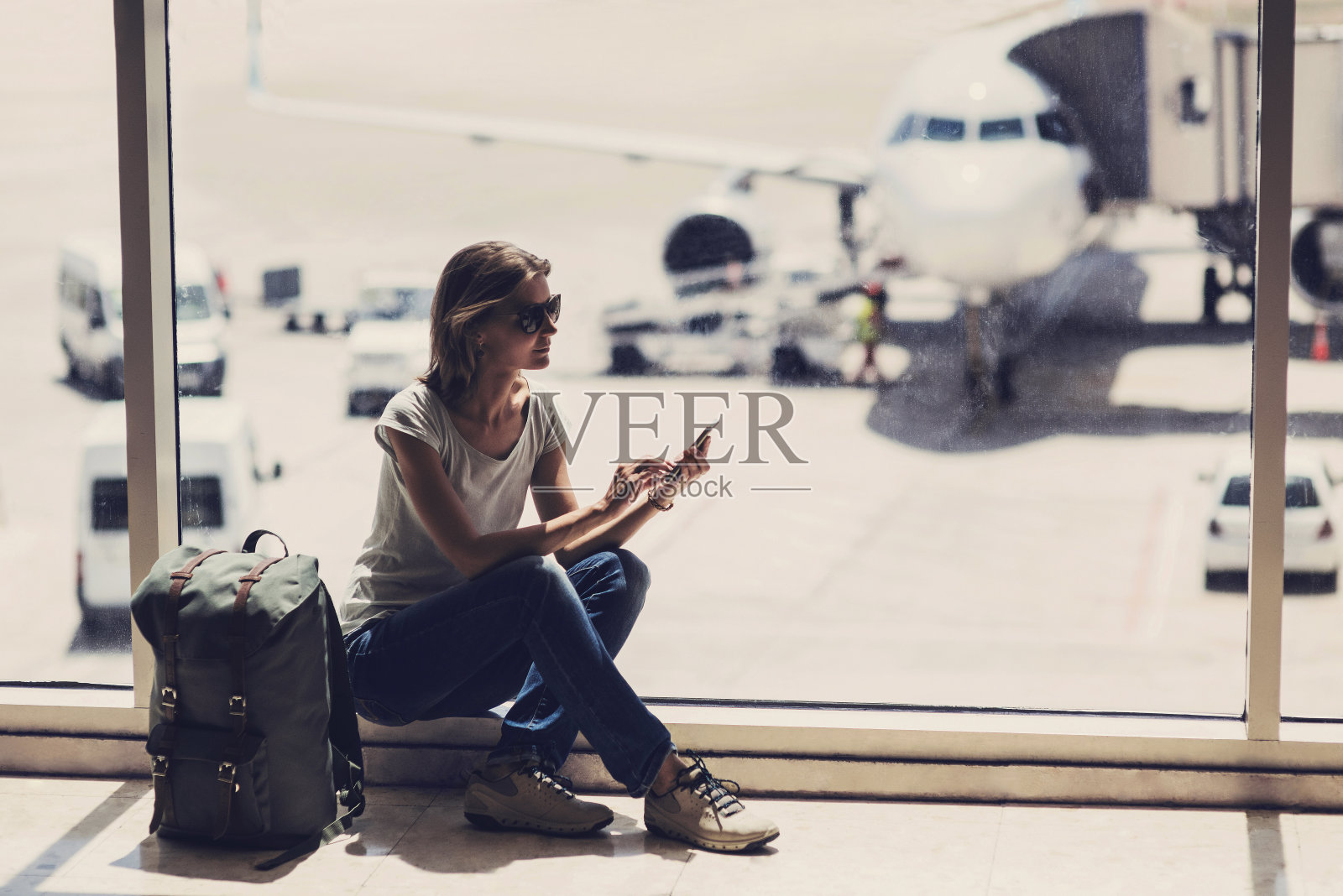 年轻女子在等飞机。旅游的概念照片摄影图片