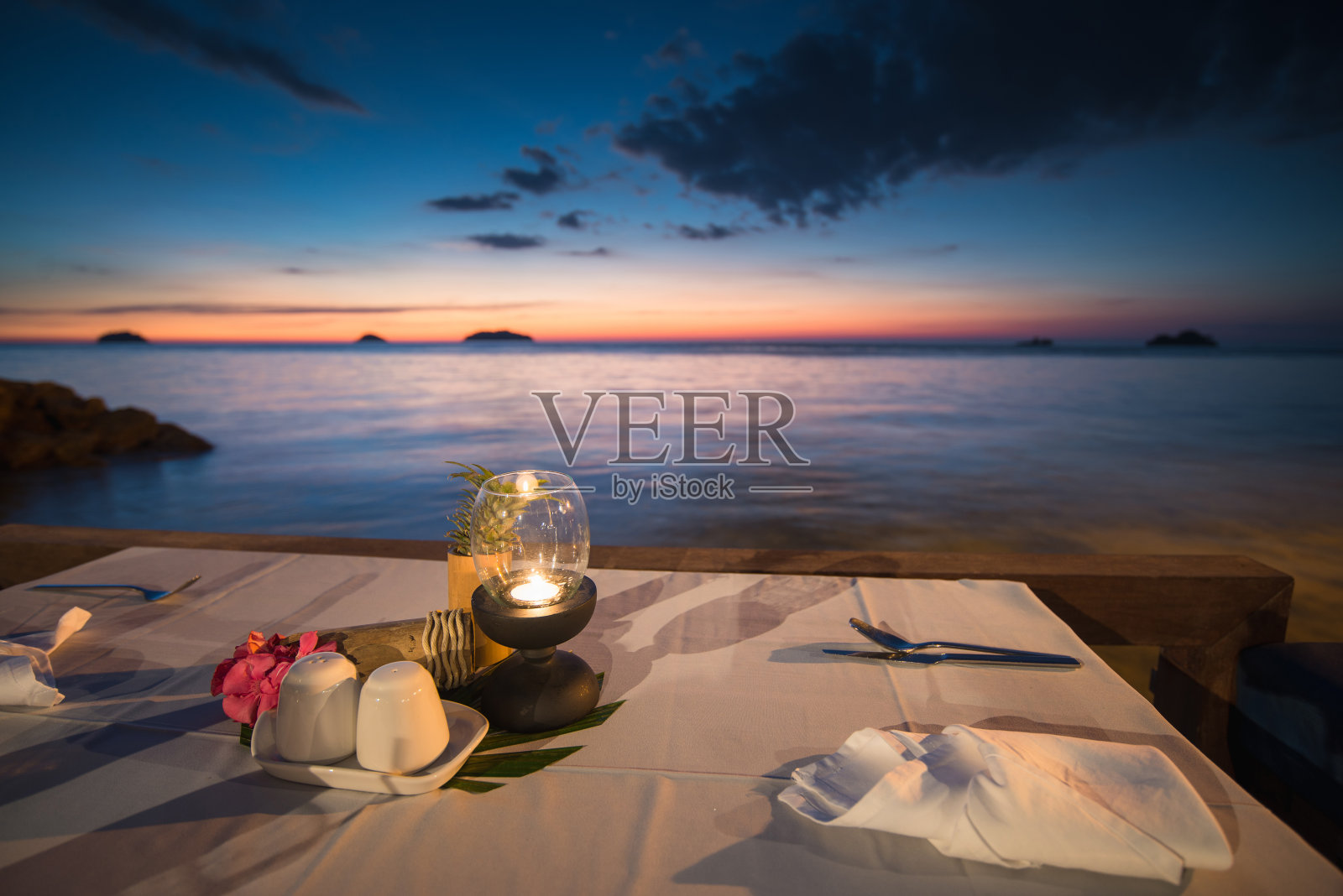 晚餐设置在泰国的海滩日落。照片摄影图片