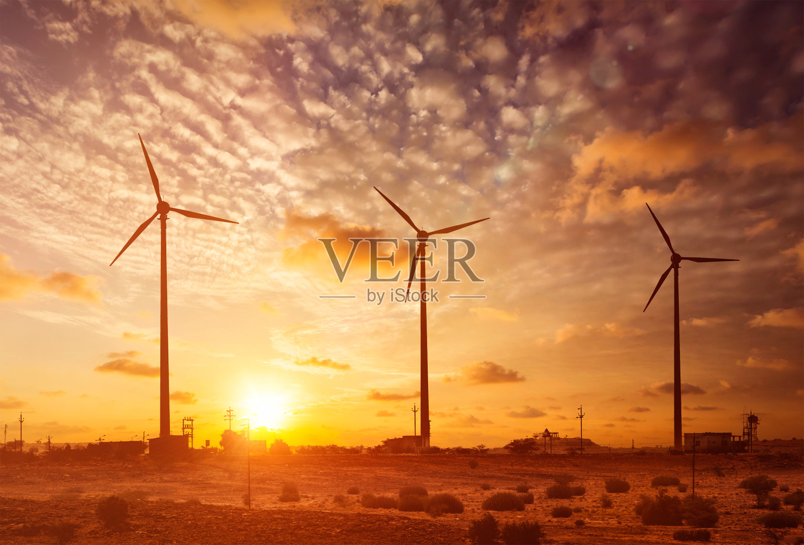 风力发电机涡轮机的轮廓在日落照片摄影图片