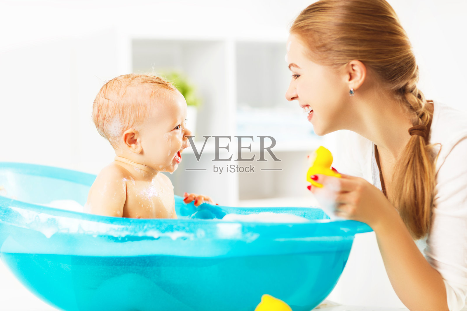 幸福的家庭妈妈在沐浴中给宝宝洗澡照片摄影图片