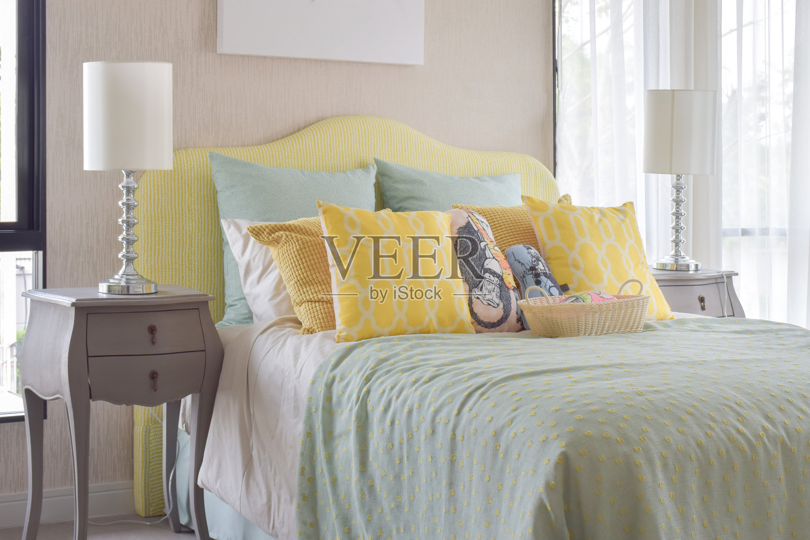 经典风格的床头柜，旁边是台灯，舒适的床上用品，还有许多绿色和黄色的枕头照片摄影图片